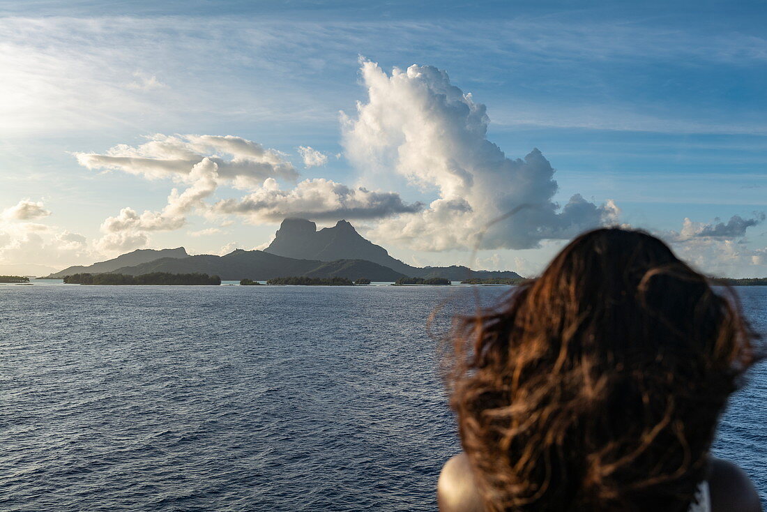 Anfahrt auf Bora Bora von Passagierfrachtschiff Aranui 5 (Aranui Cruises) aus gesehen mit Frauenkopf im Vordergrund, Bora Bora, Leeward Islands, Französisch-Polynesien, Südpazifik