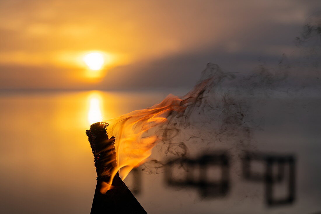 Flamme eine Tiki Fackel außerhalb des Restaurants des Tahiti Ia Ora Beach Resort (managed by Sofitel) bei Sonnenuntergang, nahe Papeete, Tahiti, Windward Islands, Französisch-Polynesien, Südpazifik