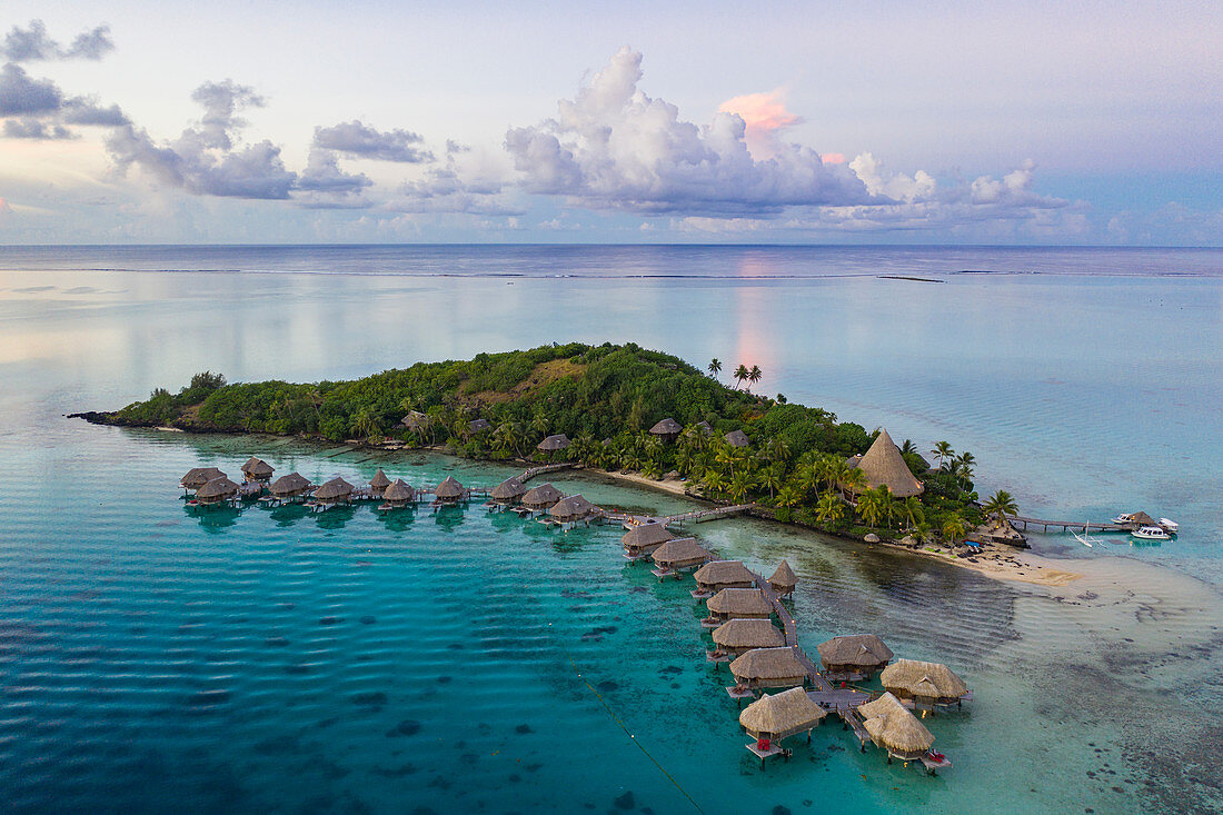 Luftaufnahme des Sofitel Bora Bora Private Island Resort mit Überwasserbungalows in der Lagune von Bora Bora bei Sonnenaufgang, Vaitape, Bora Bora, Leeward Islands, Französisch-Polynesien, Südpazifik