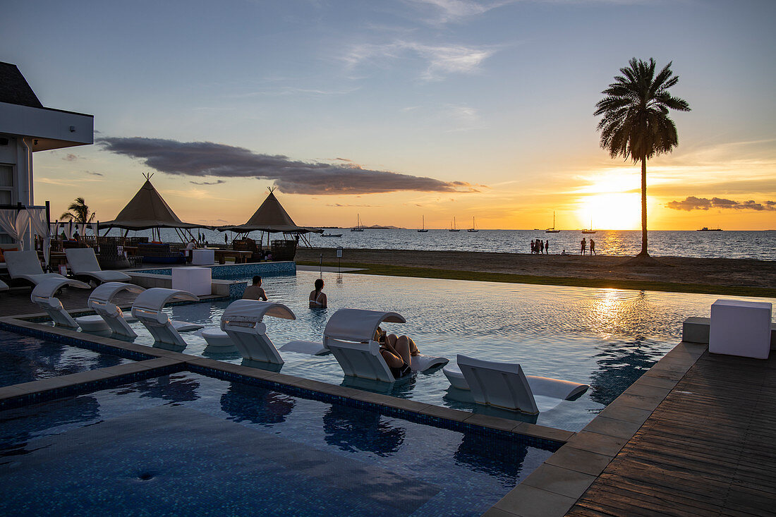 Swimming Pool und Strand im Pullman Nadi Bay Resort & Spa bei Sonnenuntergang, Nadi, Viti Levu, Fidschi-Inseln, Südpazifik