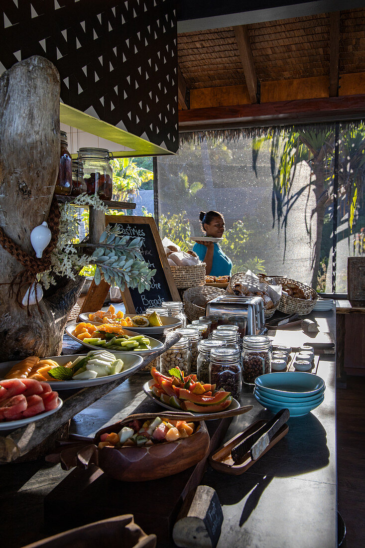 Kellnerin hinter einem fantastischen Frühstücksbuffet im Tovolea Restaurant des Six Senses Fiji Resort, Malolo Island, Mamanuca Group, Fidschi-Inseln, Südpazifik