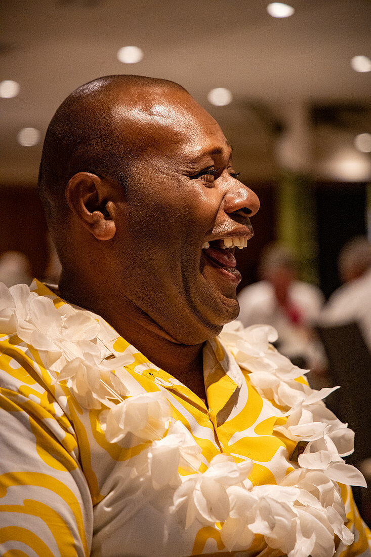 Cruise director Ilisoni Vibosi of cruise ship MV Reef Endeavor (Captain Cook Cruises Fiji) laughs during dinner in the restaurant on board, Sawa-i-Lau Island, Yasawa Group, Fiji Islands, South Pacific