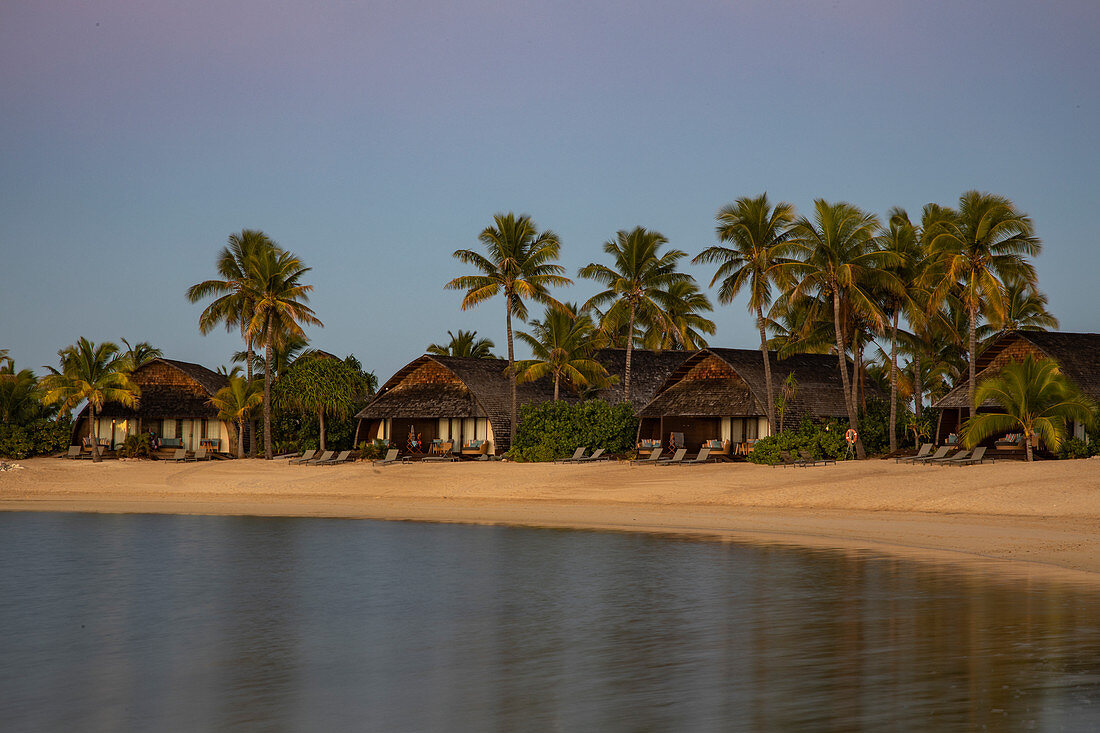 Strandbungalow und Kokospalmen im Fiji Marriott Resort Momi Bay bei Sonnenuntergang, Momi Bay, Coral Coast, Viti Levu, Fidschi-Inseln, Südpazifik