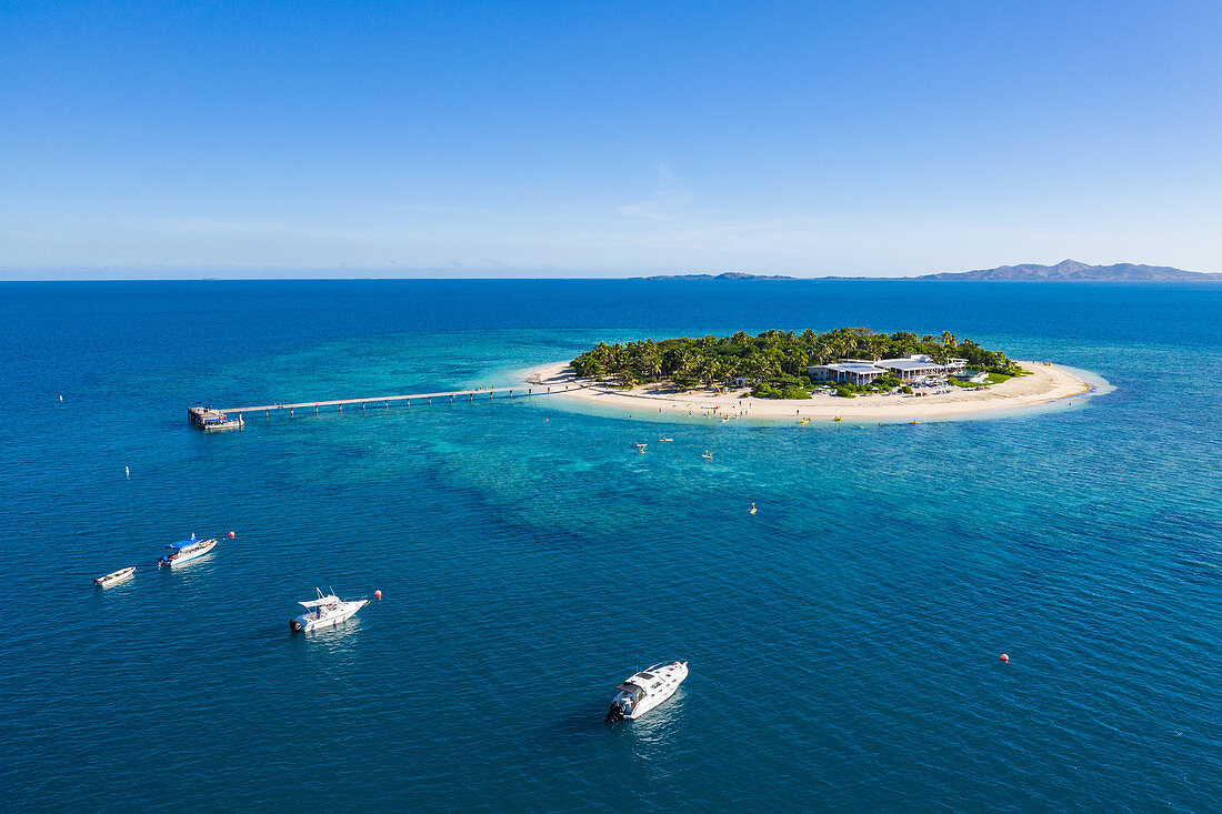 Luftaufnahme von Booten und Menschen auf SUP Stand Up Paddle Boards im Malamala Island Beach Club, Mala Mala Island, Mamanuca Group, Fidschi-Inseln, Südpazifik