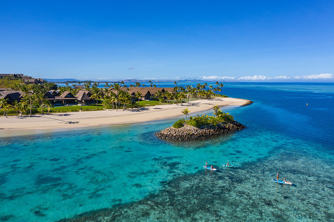 Aerial view of family enjoying water sports activities next to small barrier island at Six Senses Fiji Resort, Malolo Island, Mamanuca Group, Fiji Islands, South Pacific