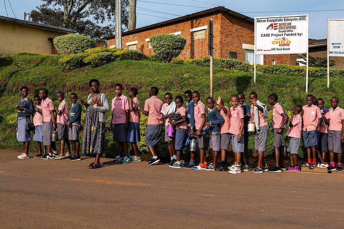 Schulkinder stehen Schlange auf dem Weg zur Schule, Gisuma, Western Province, Ruanda, Afrika 