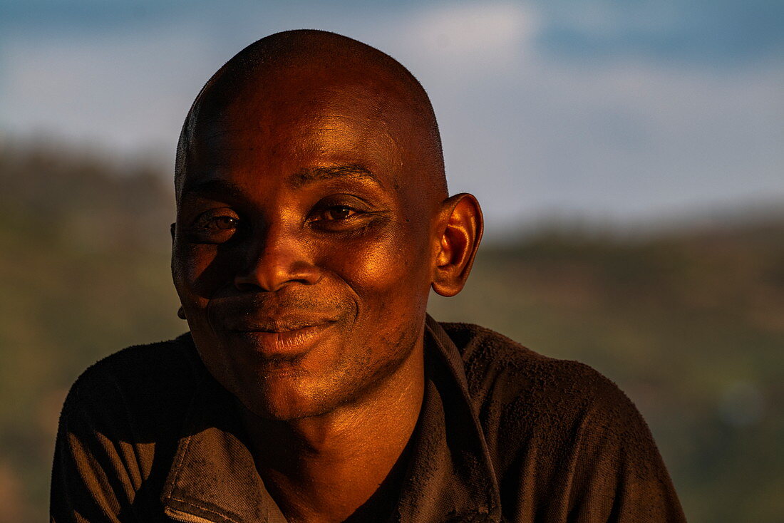 Portrait of a friendly Rwandan man in late afternoon light, Kinunu, Western Province, Rwanda, Africa