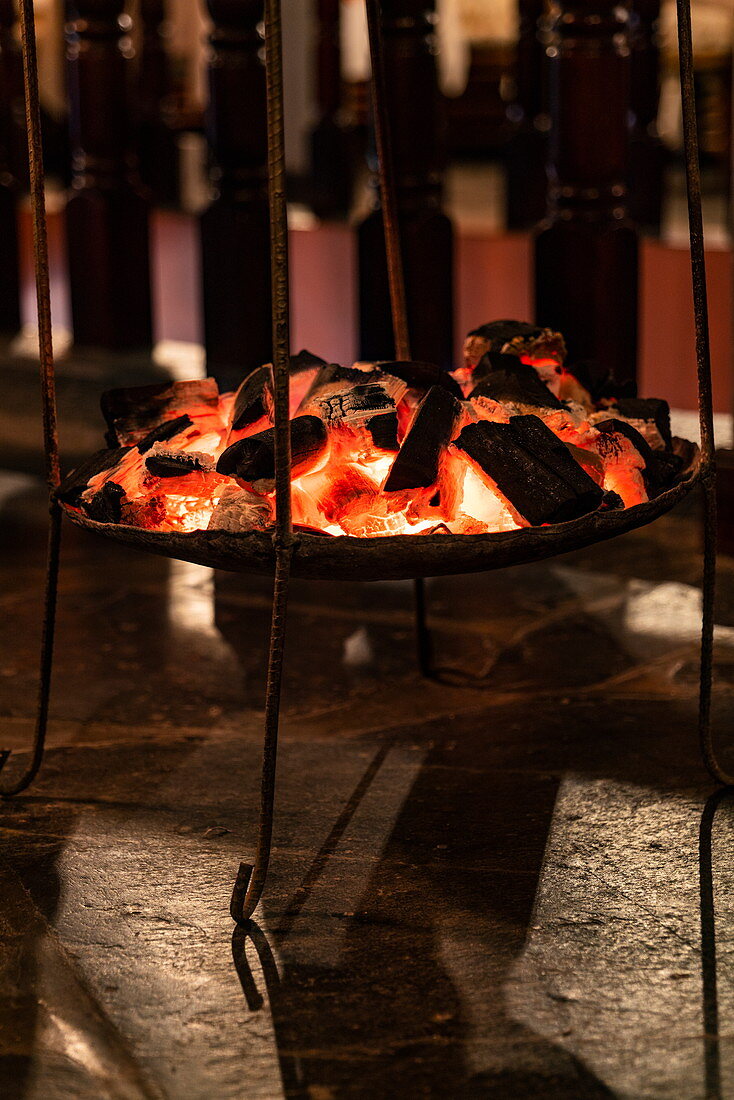 Holzkohle liefert angenehme Wärmequelle im Restaurant der Tiloreza Volcanoes Eco Lodge, Ruhengeri, Northern Province, Ruanda, Afrika