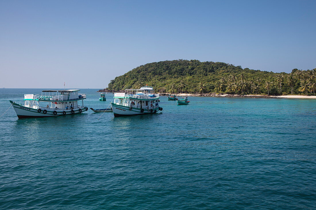 Ausflugsboote ankern vor Strand mit Kokospalmen, May Rut Island, nahe Insel Phu Quoc, Kien Giang, Vietnam, Asien