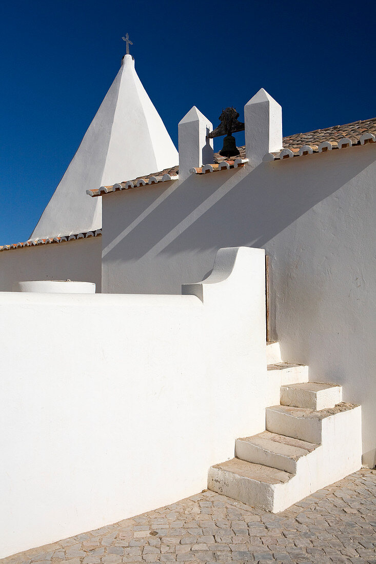 Eine weiße Kapelle an der Algarve Portugal. Architekturaufnahme mit Fokus auf Schatten und Formen.