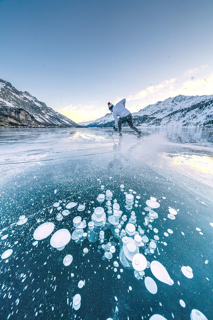 Eishockeyspieler Schlittschuh auf gefrorenem See Sils bedeckt von Blasen, Kanton Graubunden, Engadin, Schweiz