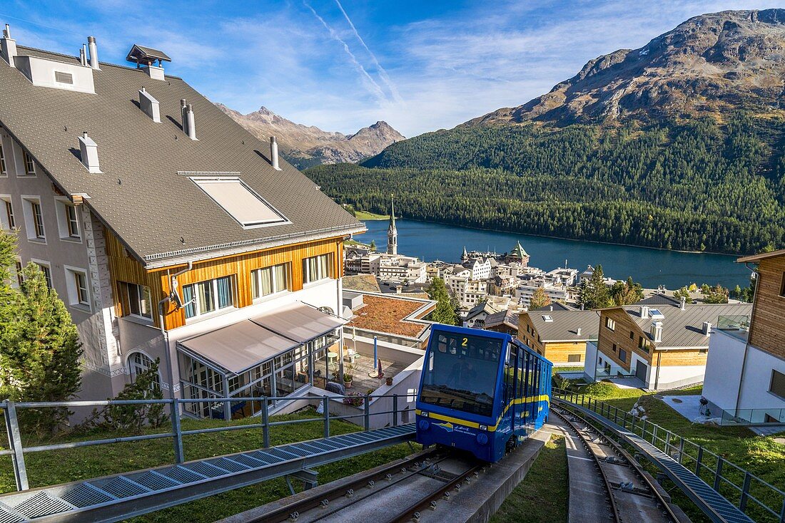 Standseilbahn, die bergauf fährt und das Bergdorf St. Moritz, Engadin, Kanton Graubunden, Schweiz überquert