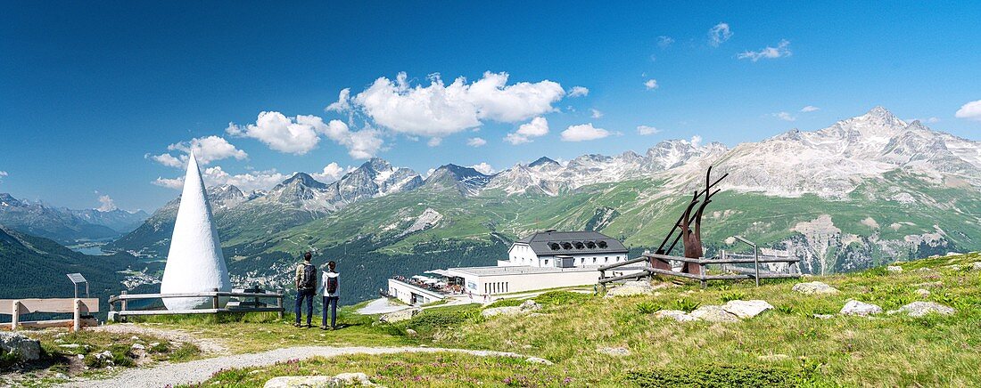 Couple admiring mountains from the funicular station at Muottas Muragl, Samedan, canton of Graubunden, Engadine, Switzerland