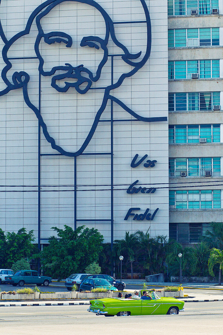 Gebäude mit Bild von Fidel Castro und Oldtimer auf der Plaza de la Revolucion in Havanna, Kuba