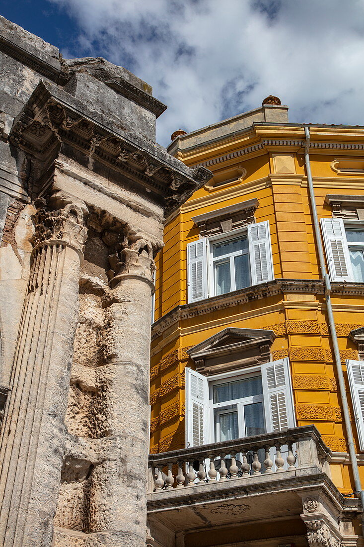 Contrast between columns of the old Roman arch of the Sergii and new building, Pula, Istria, Croatia, Europe