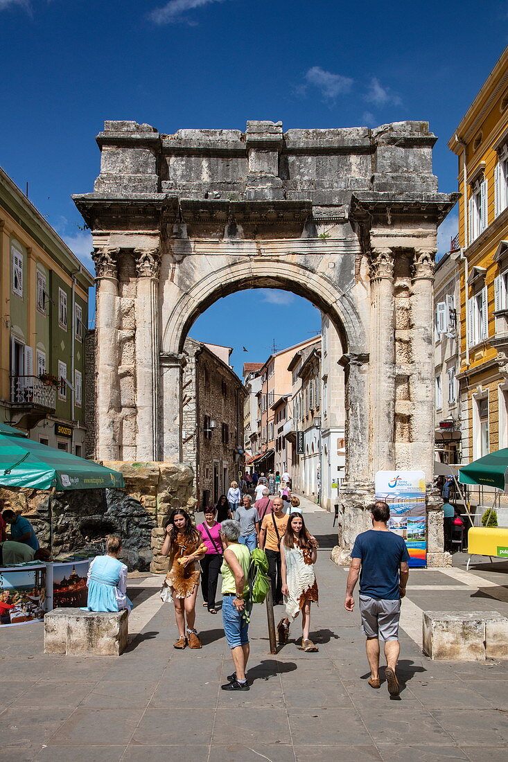 Fußgänger und der alte römische Bogen der Sergii im Zentrum der Altstadt, Pula, Istrien, Kroatien, Europa