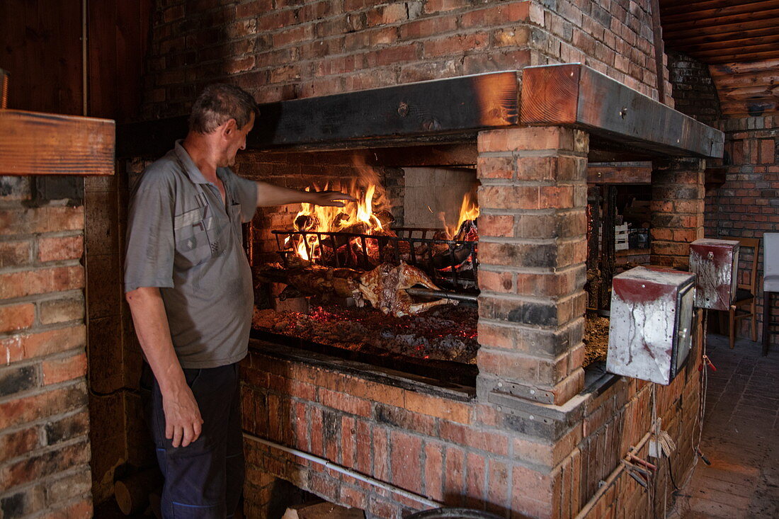 Mann grillt Fleisch im Restaurant Macola, Korenika, Lika-Senj, Kroatien, Europa