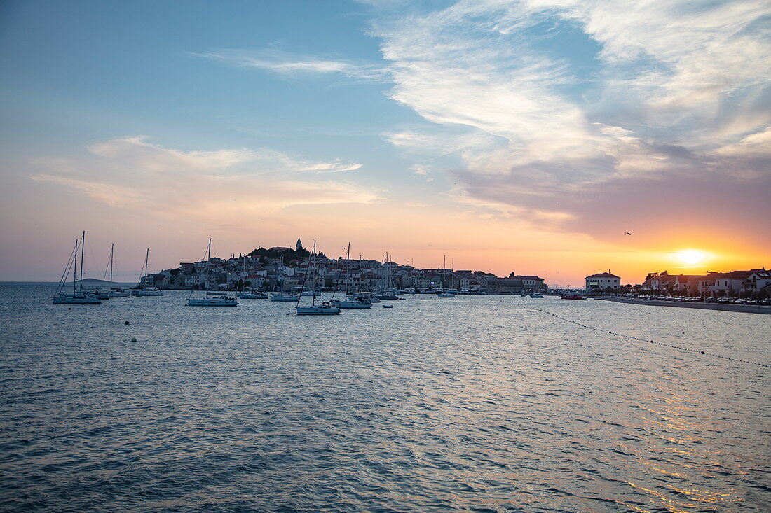 Segelboote ankern im Hafen mit Altstadt in der Ferne bei Sonnenuntergang, Primosten, Šibenik-Knin, Kroatien, Europa