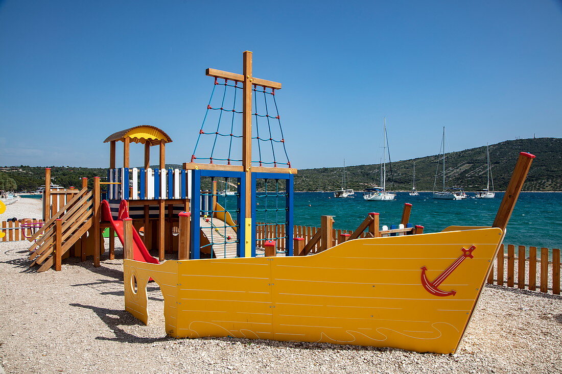 Spielplatz für Kinder am Strand mit gelbem Boot, Primosten, Šibenik-Knin, Kroatien, Europa