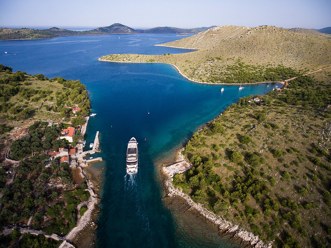 Luftaufnahme von Kreuzfahrtschiff in enger Passage zwischen Inseln, Nationalpark Kornati-Inseln, Šibenik-Knin, Kroatien, Europa