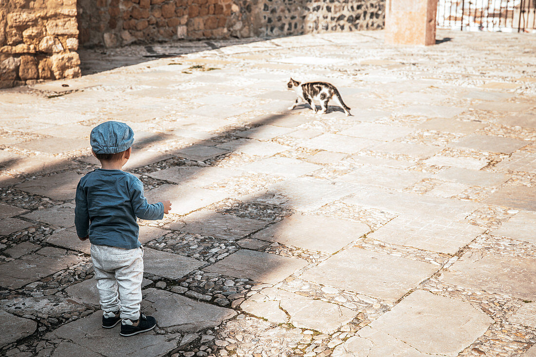 Child watches the cat in Marbella, Spain