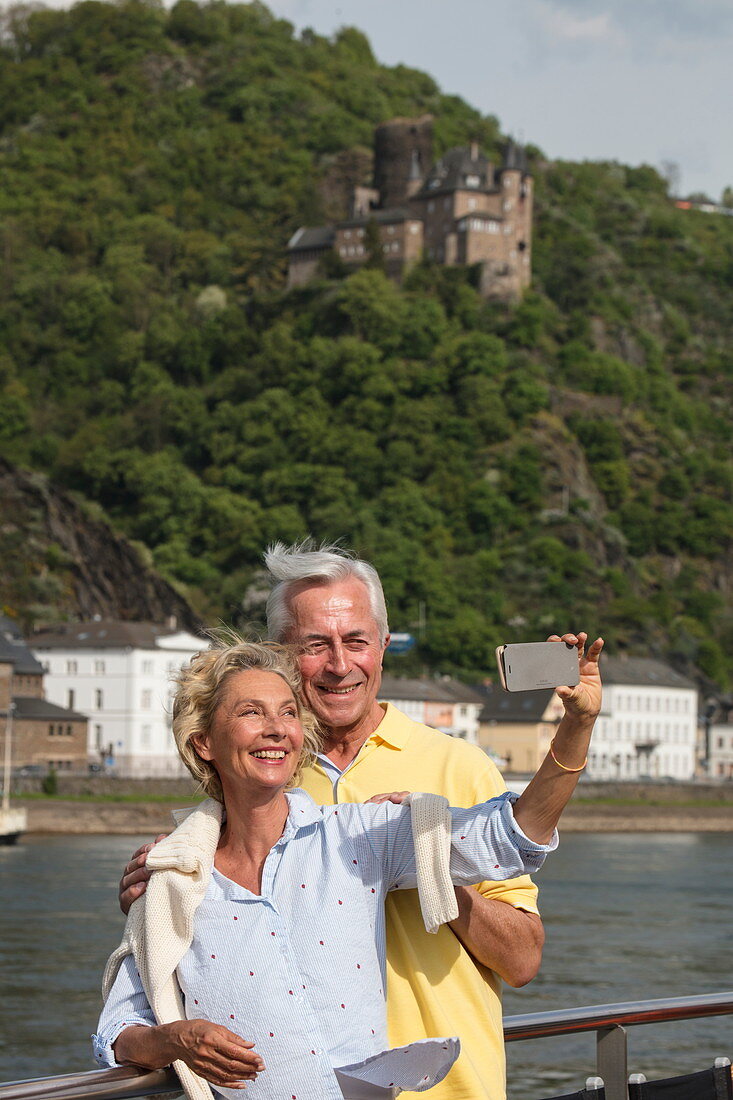 Couple makes selfie photo on sundeck of river cruise ship during a cruise on the Rhine, Sankt Goarshausen, Rhineland-Palatinate, Germany, Europe