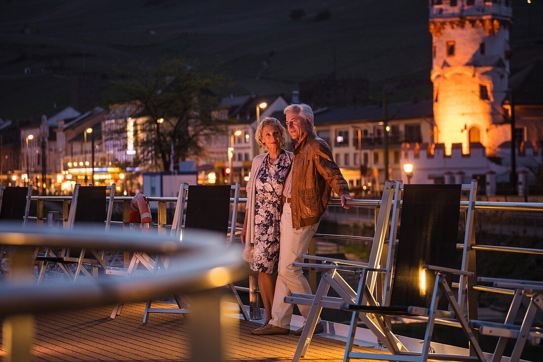 Couple on sundeck of river cruise ship during a cruise on the Rhine at dusk, Ruedesheim am Rhein, Hesse, Germany, Europe