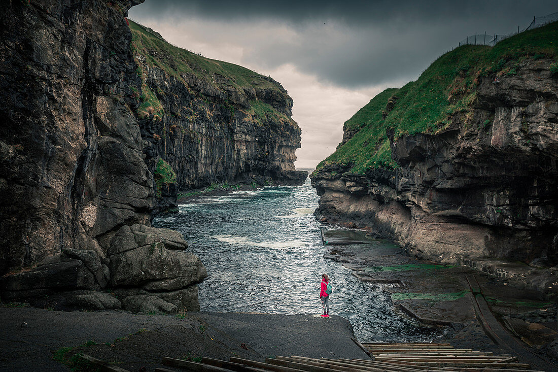 Woman in the gorge in the village of Gjogv on Eysteroy, Faroe Islands