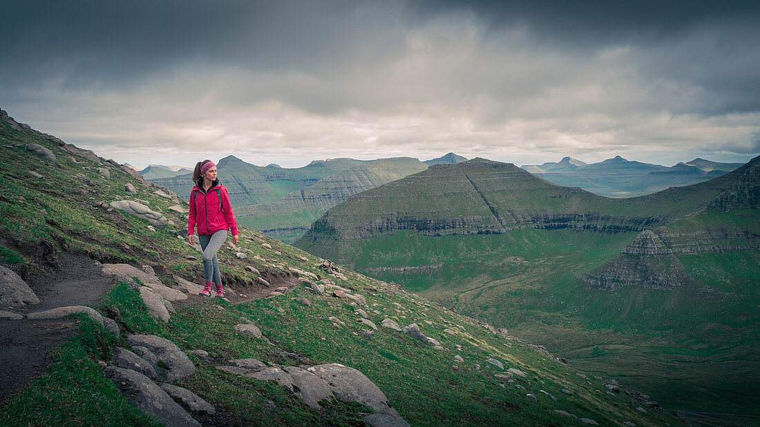 Woman hiking on Slættaratindur summit on Eysteroy, Faroe Islands