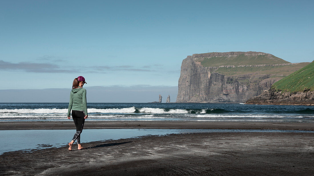 Frau am Sandstrand im Dorf Tjørnuvík auf Streymoy auf Färöer Inseln bei Tag\n