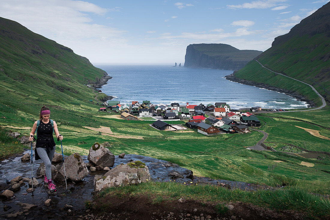 Frau beim Wandern über Dorf Tjørnuvík auf Streymoy auf Färöer Inseln bei Tag\n