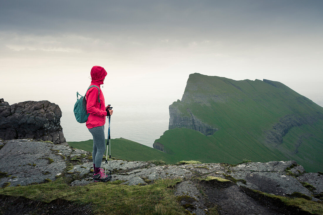 Frau wandert in den Bergen von Streymoy bei Regen, Färöer Inseln\n