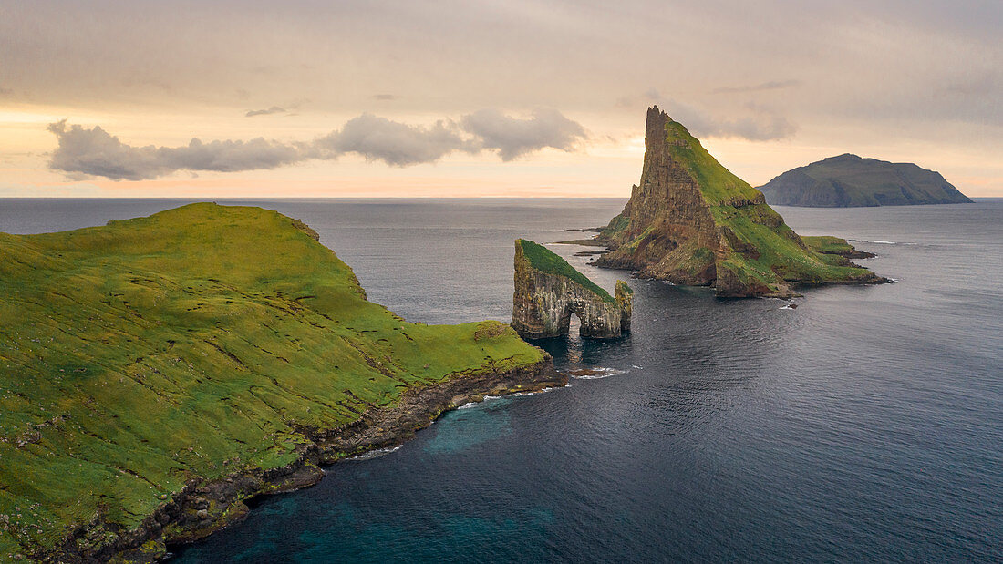 Felsformationen von Drangarnier und Insel Tindholmur und Mykines im Sonnenuntergang auf Vagar, Färöer Inseln