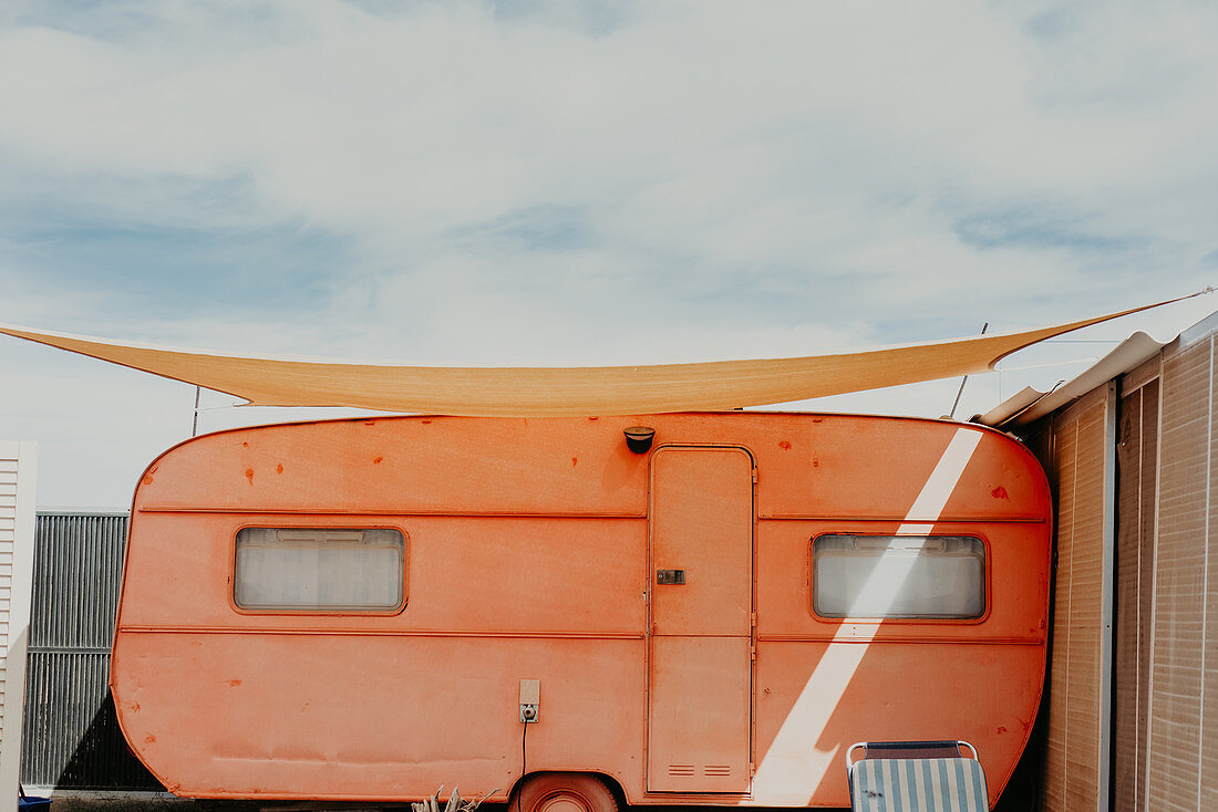 Exterior view of vintage orange camper van with sun-sail on Fuerteventura.