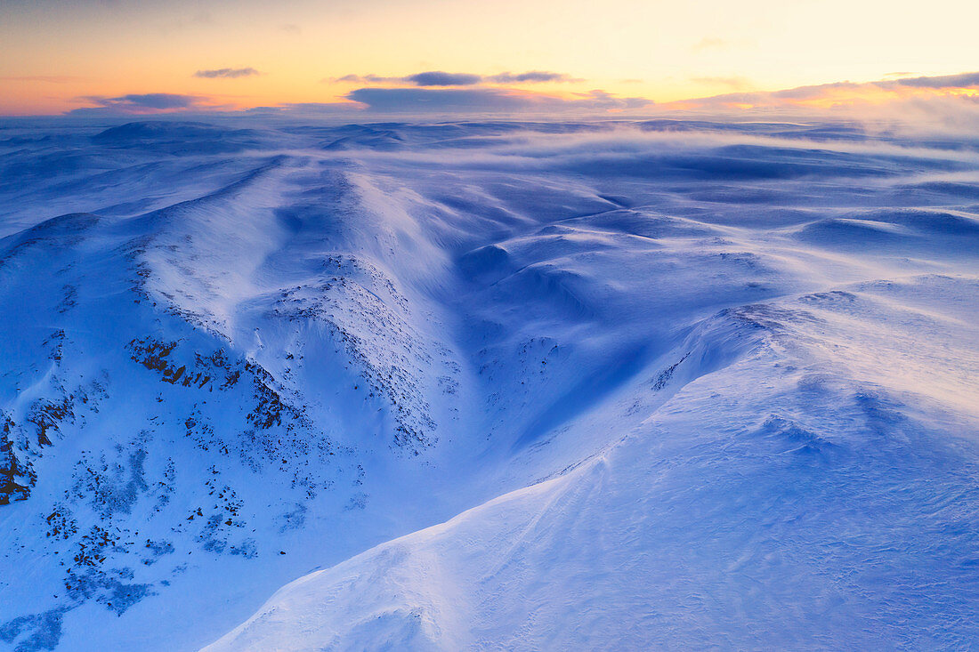 Neuschnee geformt durch den kalten arktischen Wind, der über Berge im Morgengrauen weht, Tana, Troms og Finnmark, Nordnorwegen, Skandinavien, Europa