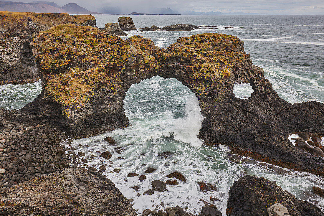 A rock arch among basalt lava cliffs at Arnastapi, on the coast of the Snaefellsnes peninsula, west Iceland, Polar Regions