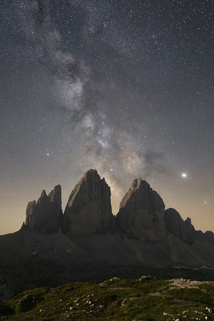 the milky way shines in the summer night sky above the Tre Cime di Lavaredo, Dolomiti, municipality of Auronzo di Cadore and Dobbiaco, Belluno and Bolzano province, Veneto and Trentino Alto adige district, Italy, Europe