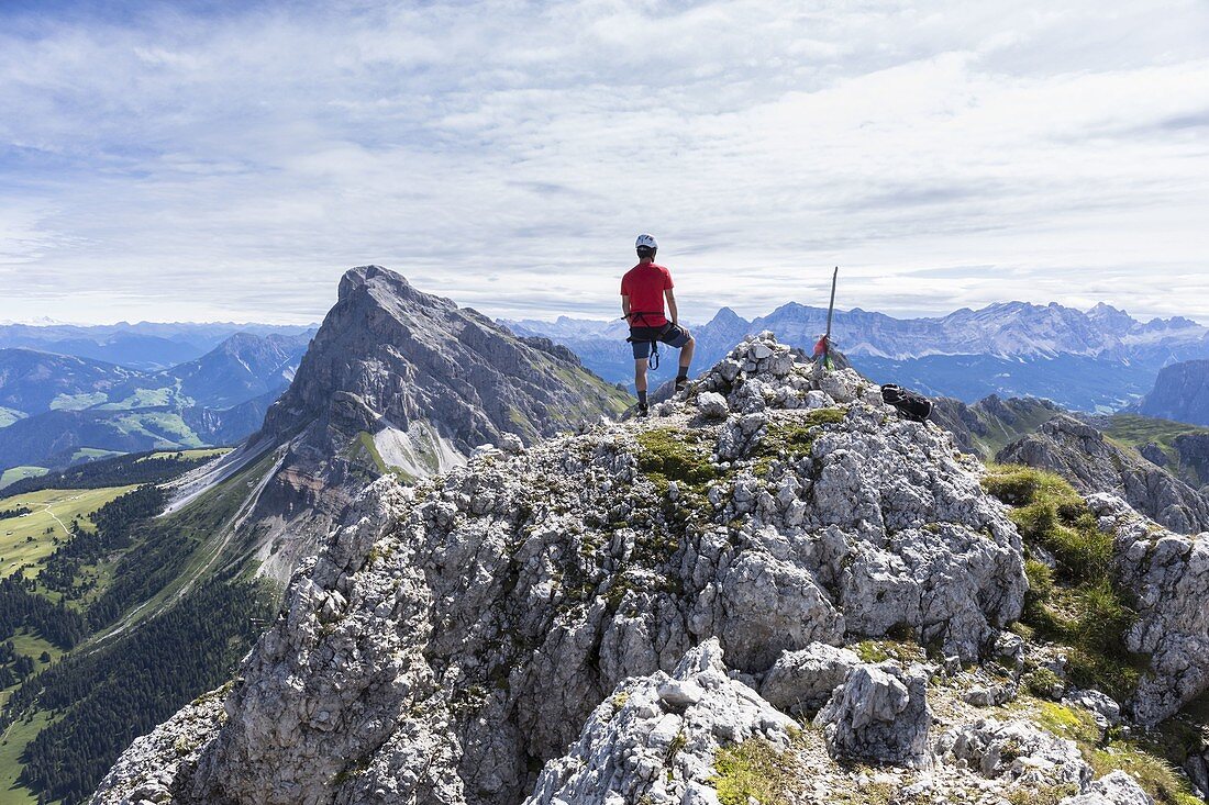 A climber along the via ferrata Günther Messner on the Aferer Geisler with Peitlerkofel in the background, Bolzano province, South Tyrol, Trentino Alto Adige, Italy
