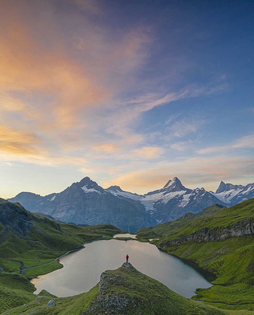 Hiker admiring Bachalpsee lake at surise, Grindelwald Bernese Oberland Canton of Berne Switzerland Europe