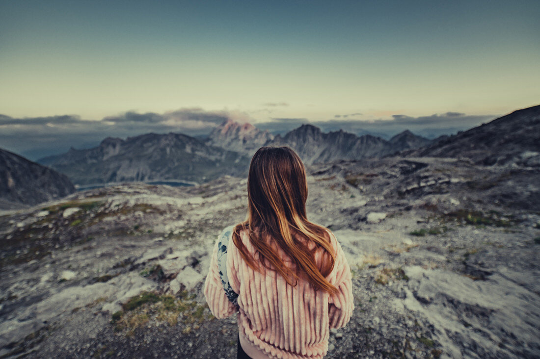 Frau sitzt in den Bergen im Rätikon über dem Lünersee, Vorarlberg, Österreich, Europa