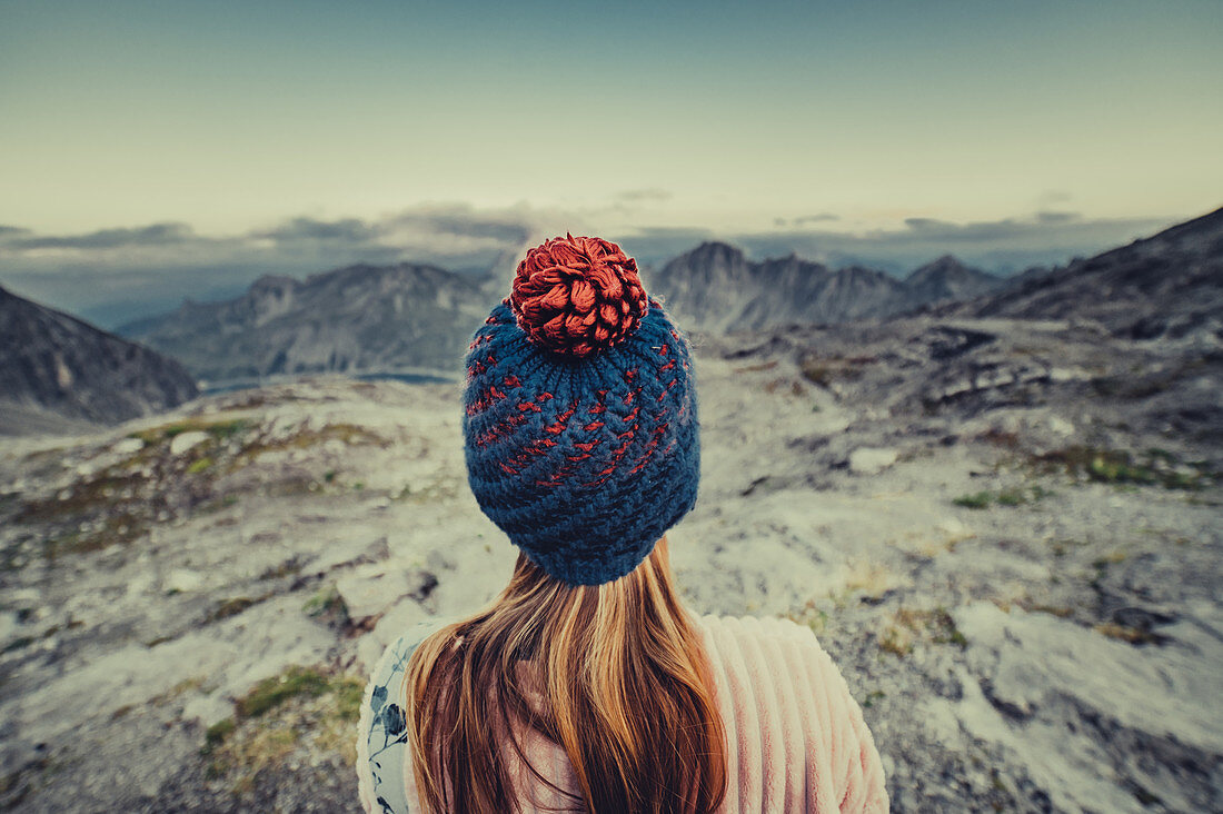 Frau mit Mütze steht auf einem Berg beim Lünersee, Vorarlberg, Österreich, Europa