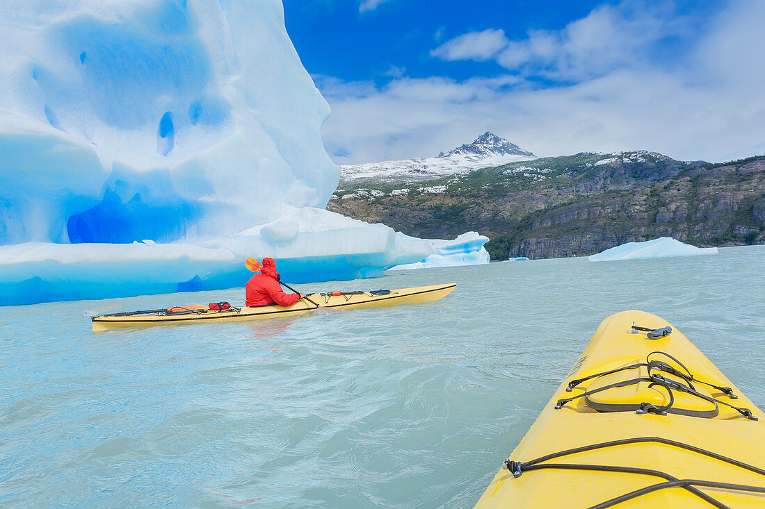 Kayaker paddling near icebergs, Torres del Paine National Park, Chile, South America
