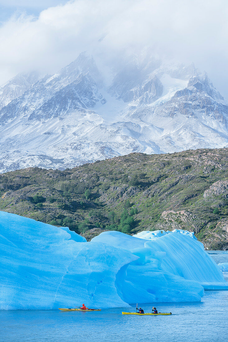 Kajakfahrer paddeln unter Eisbergen, Nationlapark Torres del Paine, Patagonien, Chile, Südamerika