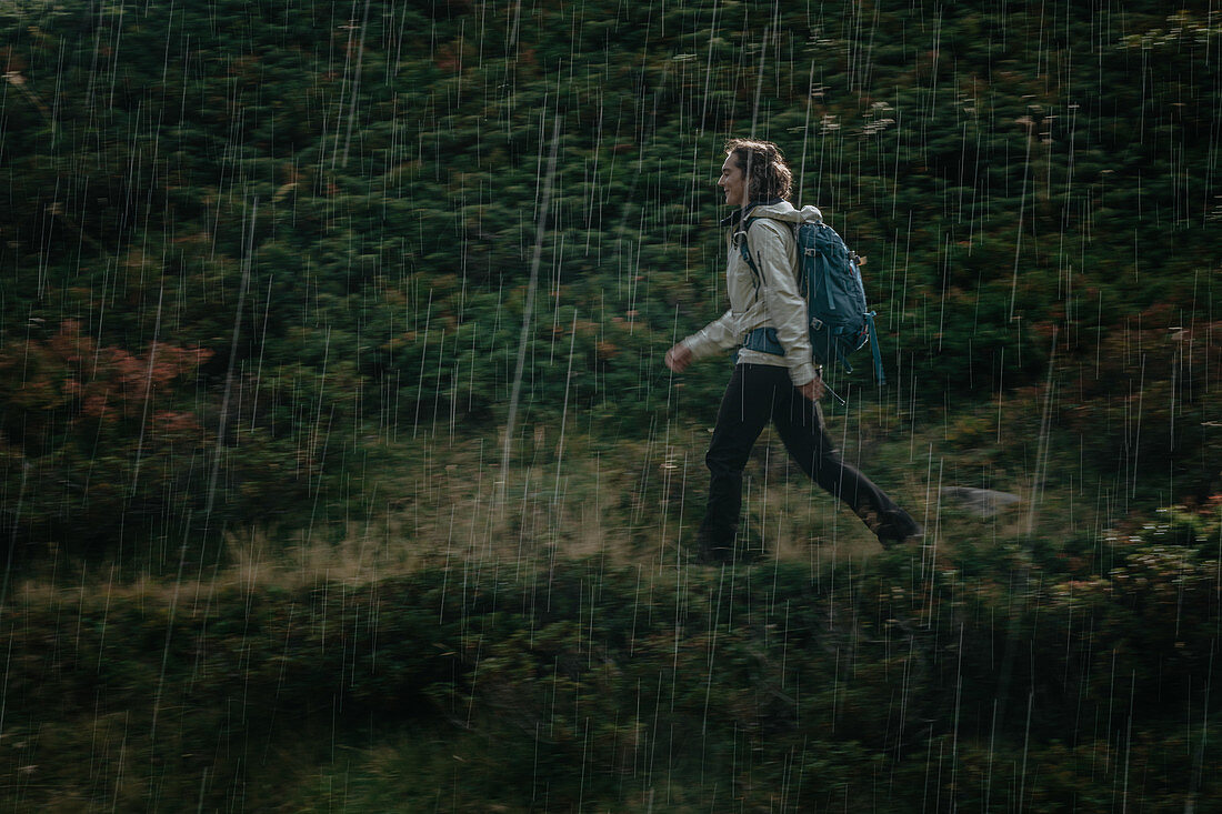 Frau wandert durch Regen in den Bergen, Schweiz