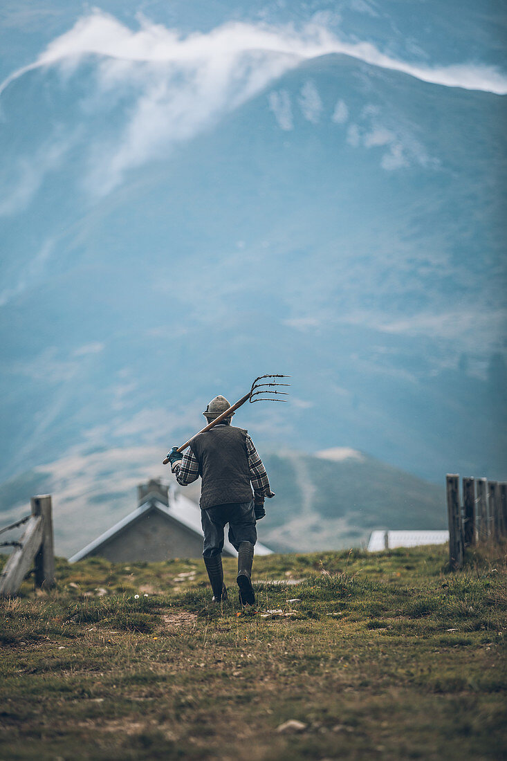 Alter Bergbauer auf dem Weg zur Berghütte, Schweiz