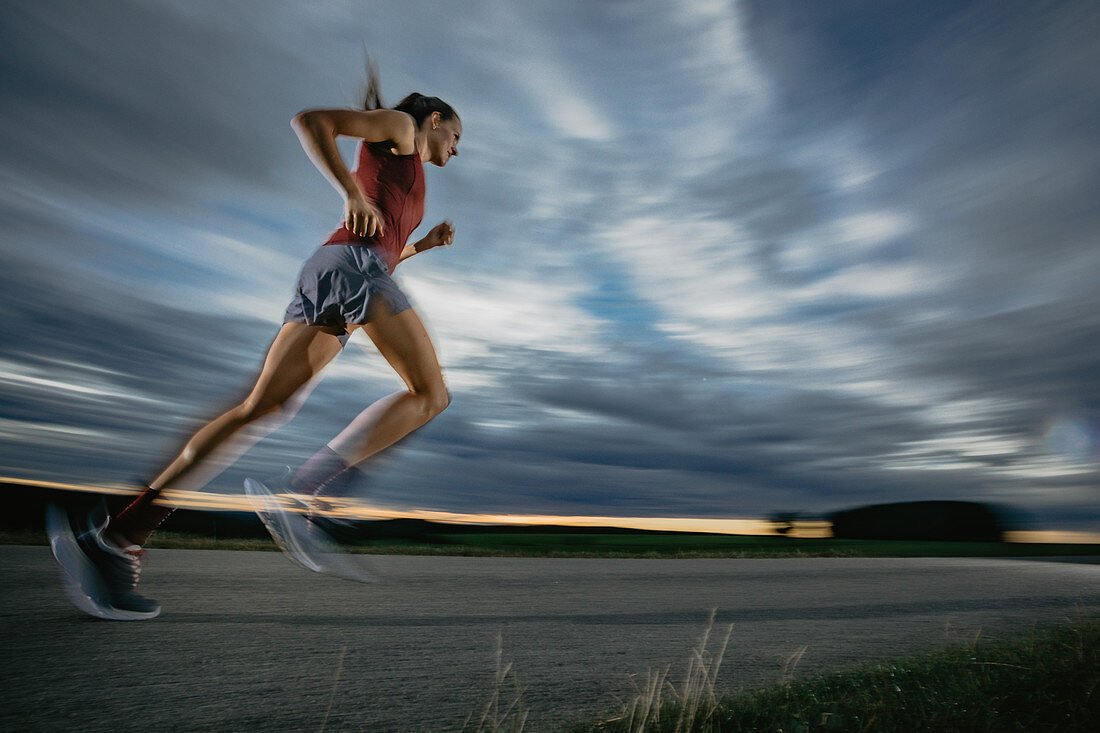 Woman runner runs on road in sunset, sport, forest