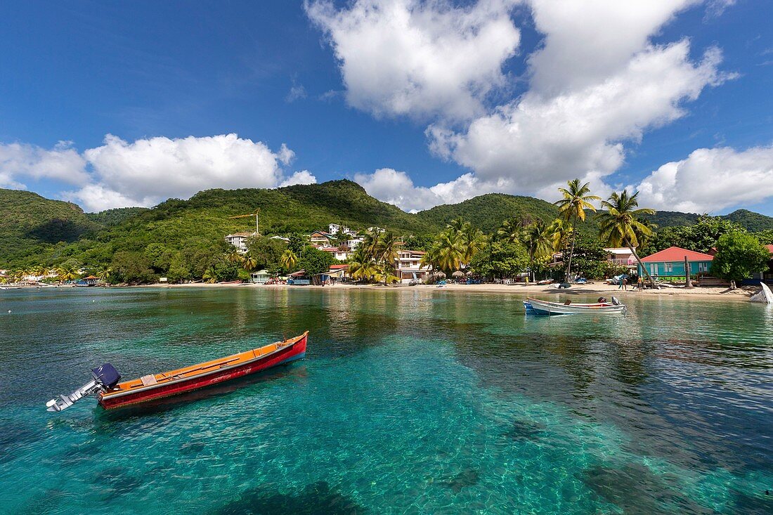 Martinique, Blick auf den Strand von Anses d'Arlets, weißer Sand, Kokosnüsse, türkisfarbenes Meer im Vordergrund Fischerboote das typische Boot der Westindischen Inseln