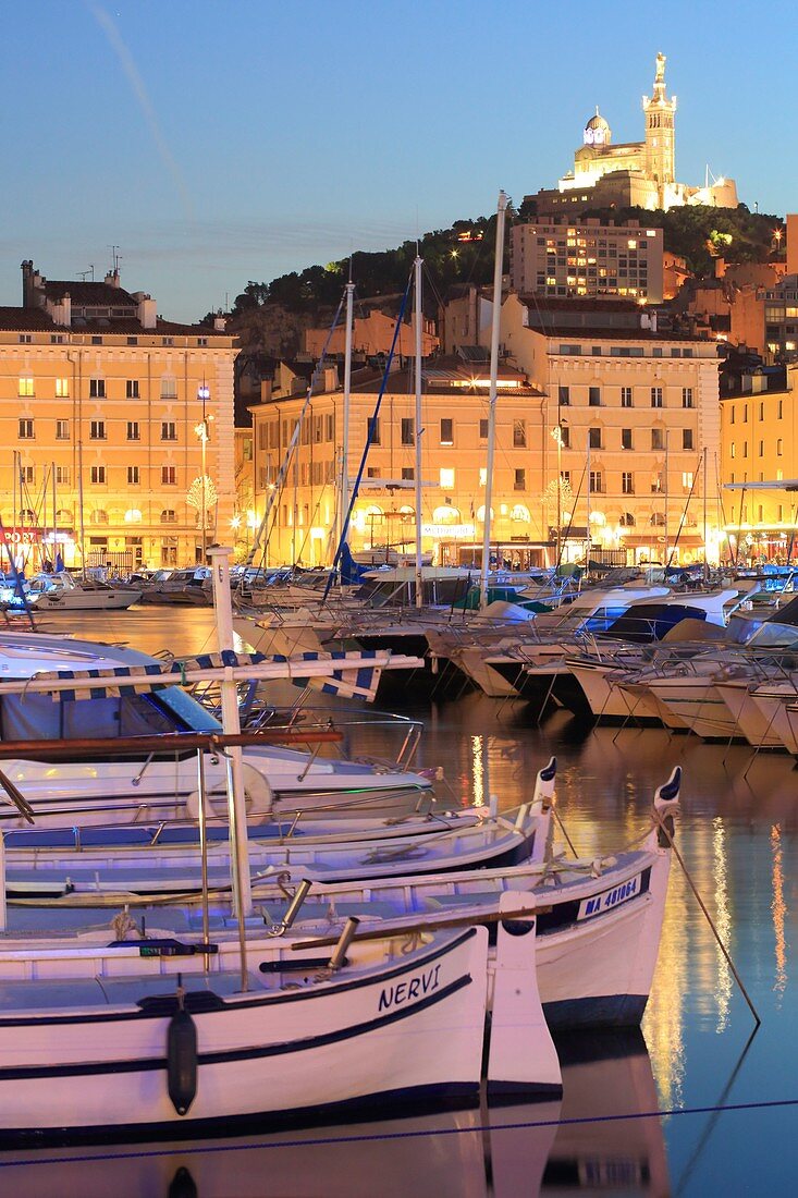 France, Bouches du Rhone, Marseille, Vieux Port and its sharp (traditional fishing boats) with at the bottom the Basilica of Our Lady of the Guard