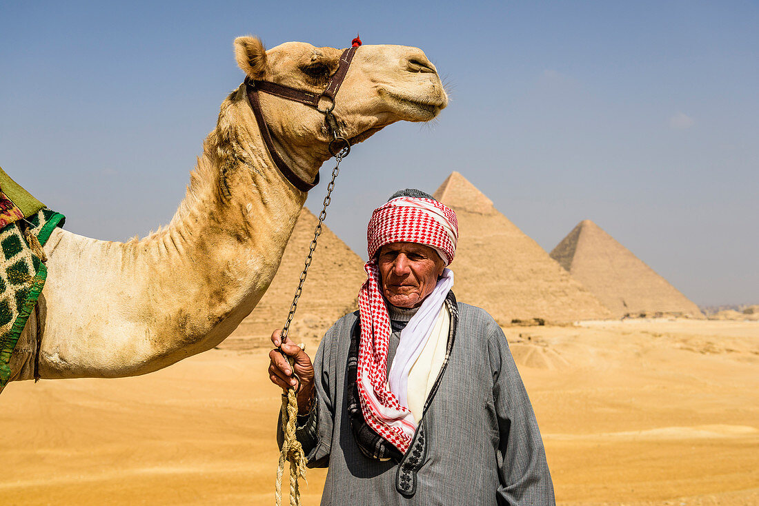 Three pyramids, monuments and burial tombs of the pharaohs Khufu, Khafre, and Menkaure, a tourist guide holding a camel