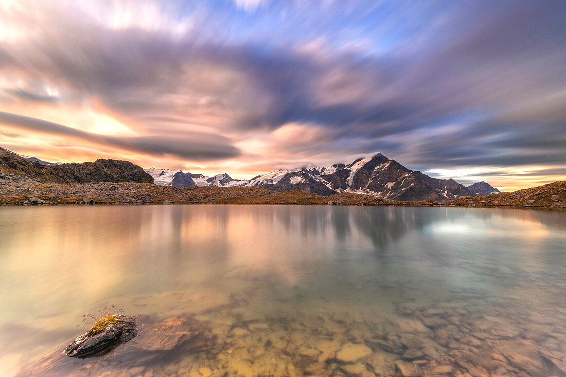 Dramatischer Himmel bei Sonnenaufgang über Tresero-Spitze reflektiert in See Manzina, Valfurva, Valtellina, Provinz Sondrio, Lombardei, Italien, Europa